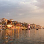 Ghats of Varanasi seen from the holy Ganges river at sunrise.